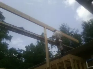 Carpenter setting a ridge beam over a new addition frame — Ice Dam Removal by Roofing Brothers in Palacios