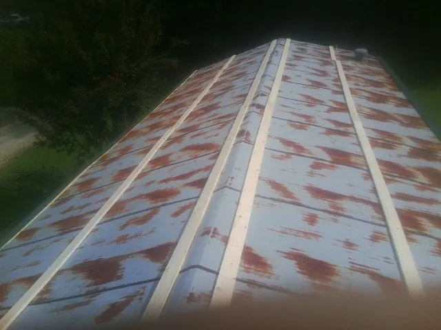 Rusted metal roof panels with new wood purlins before replacement — Storm Damage Roof Repair in Palacios by Roofing Brothers