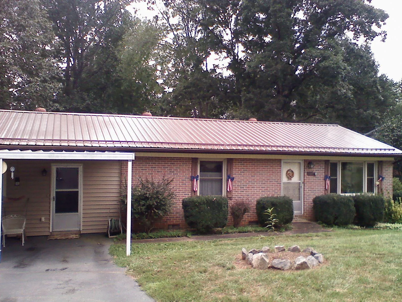 Bronze metal roof and carport on a brick ranch home — Roof Repair work by our crew in Palacios