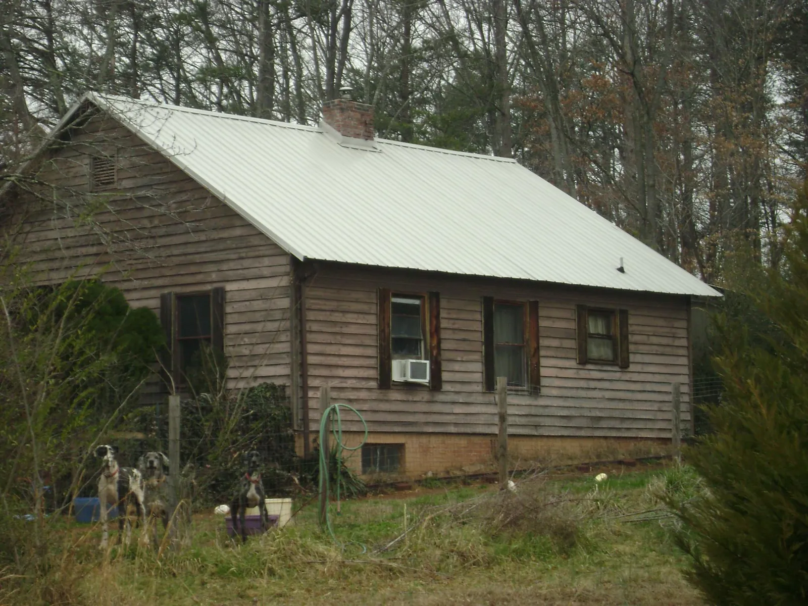 White metal roof on an old wood sided farmhouse, from a Metal Roof Installation job in Palacios